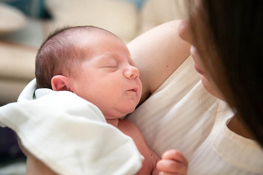 woman holding a newborn in her arms