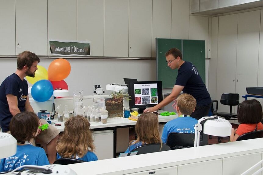 Researchers explaining soil microbes to kids